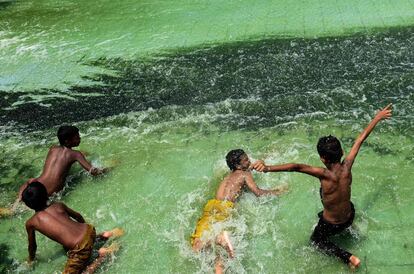 Niños bangladesíes juegan en una piscina en Daca, capital de Bangladés.