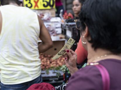 Una clienta espera a un vendedor en un puesto de frutas en Ciudad de México, el 9 de mayo de 2023.