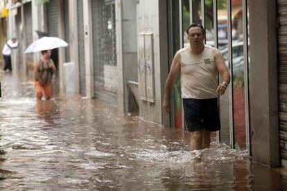 Un hombre camina por una de las calles de Santa Cruz de Tenerife inundadas por el temporal.