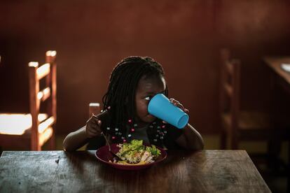 Una niña almuerza en la 'escolinha' o escuela de educación infantil del barrio cuatro de Massaca, que tiene un total de seis. Este centro educativo, al que acuden 45 alumnos por ahora, fue inaugurado el pasado mes de mayo.