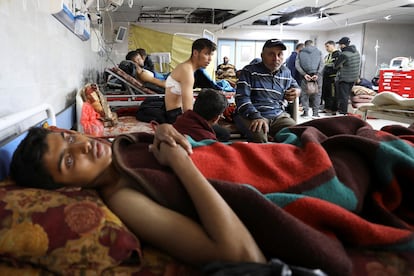 Varios palestinos que resultaron heridos al disparar el jueves el ejército israelí contra una multitud que intentaba recoger alimentos de un convoy de camiones en la Franja, son atendidos este viernes en el hospital Al Shifa, en Ciudad de Gaza.