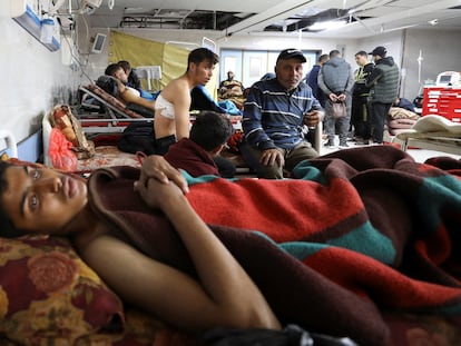 Varios palestinos que resultaron heridos al disparar el jueves el ejército israelí contra una multitud que intentaba recoger alimentos de un convoy de camiones en la Franja, son atendidos este viernes en el hospital Al Shifa, en Ciudad de Gaza.