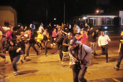 Los manifestantes huyen de los gases lacrimógenos en Ferguson.
