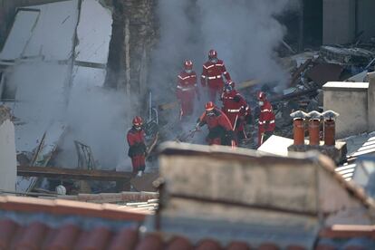 Firefighters move through the rubble at 'rue Tivoli' after a building collapsed in the street, in Marseille, southern France, on April 9, 2023