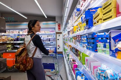 Una mujer observa el lineal de un supermercado.