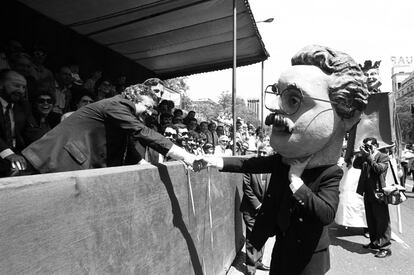 Joaqu&iacute;n Leguina, presidente de la Comunidad de Madrid desde 1983 hasta 1995, saluda a un cabezudo que porta su cabeza.
