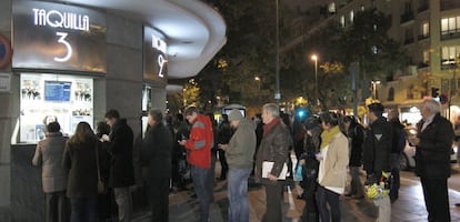 Varias personas hacen cola en la taquilla de un cine en Madrid. 