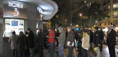 Varias personas hacen cola en la taquilla de un cine en Madrid.