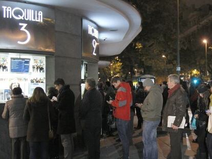 Varias personas hacen cola en la taquilla de un cine en Madrid. 