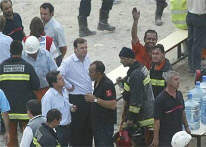 El ministro de Defensa, Federico Trillo, charla con los bomberos después del rescate de los trabajadores atrapados en el túnel.