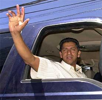 Lucio Gutiérrez saluda a sus simpatizantes mientras abandona el hotel de Quito donde celebró su victoria.