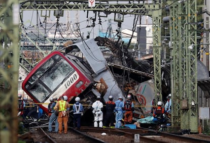 Los oficiales de rescate, la policía y los empleados de la compañía ferroviaria trabajan en la escena donde un tren descarriló durante una colisión con un camión en Yokohama, cerca de Tokio (Japón)