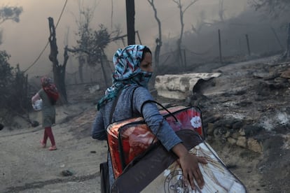 El campo de refugiados de Moria, en la isla griega de Lesbos, aloja a unos 13.000 refugiados. En la imagen, una mujer traslada sus pertenencias tras el incendio.