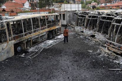 Un hombre camina junto a los autobuses quemados durante una protesta después de que Evo Morales anunciara el domingo su renuncia.