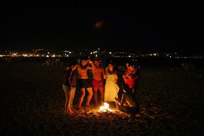 Un grupo de jóvenes baila junto a una hoguera en la playa de 'La Misericordia' en Málaga.