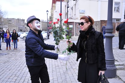 Un mimo regala una flor a una mujer en Baku, capital de Azerbaiyán.