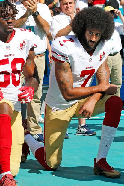 Colin Kaepernick arrodillado durante el himno de Estados Unidos.