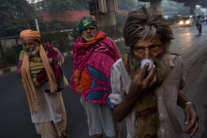 Personas sin hogar piden limosma en la puerta del templo hind del dios del mono, Hanuman, en Nueva Delhi, India.