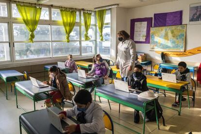 Una maestra da clases a estudiantes con mascarillas en una escuela pública en Montevideo, Uruguay.
