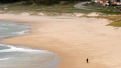 Una mujer de paseo con su perro por la playa de Doniños, en Ferrol (A Coruña).
