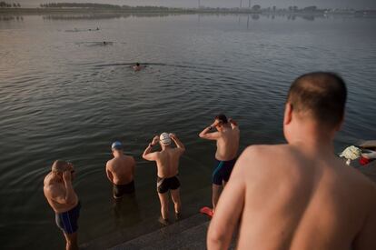 Habitantes de Dandong se preparan para su rutina de natación matinal en el río.