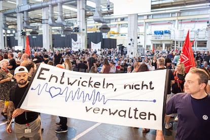 Un grupo de trabajadores se manifiesta en la planta de Volkswagen en Wolfsburgo frente a la cúpula directiva del grupo. Dos empleados sostienen una pancarta que dice "Desarrollar, no gestionar".