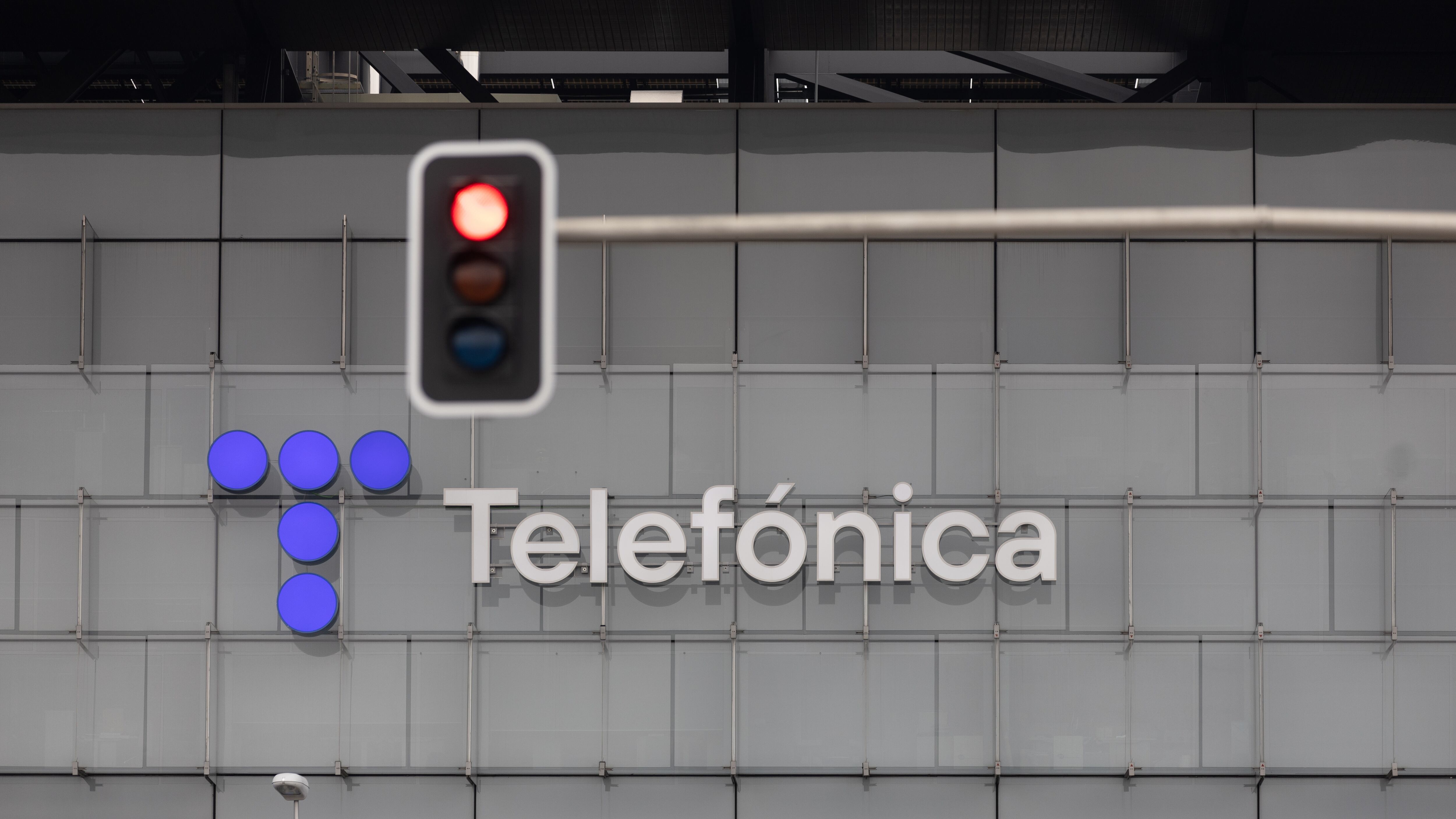 Un semáforo en rojo frente a la sede de Telefónica, en Madrid.