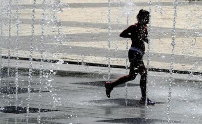 A woman runs through some fountains in Madrid’s Juan Carlos I park on Wednesday.