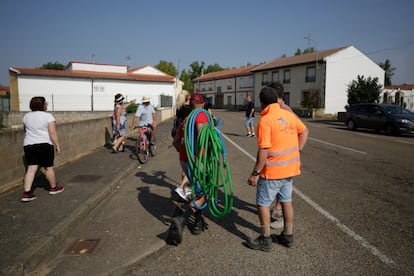 Un grupo de vecinos, con mangueras a cuestas, este viernes en Villamontán de la Valduerna (León).
