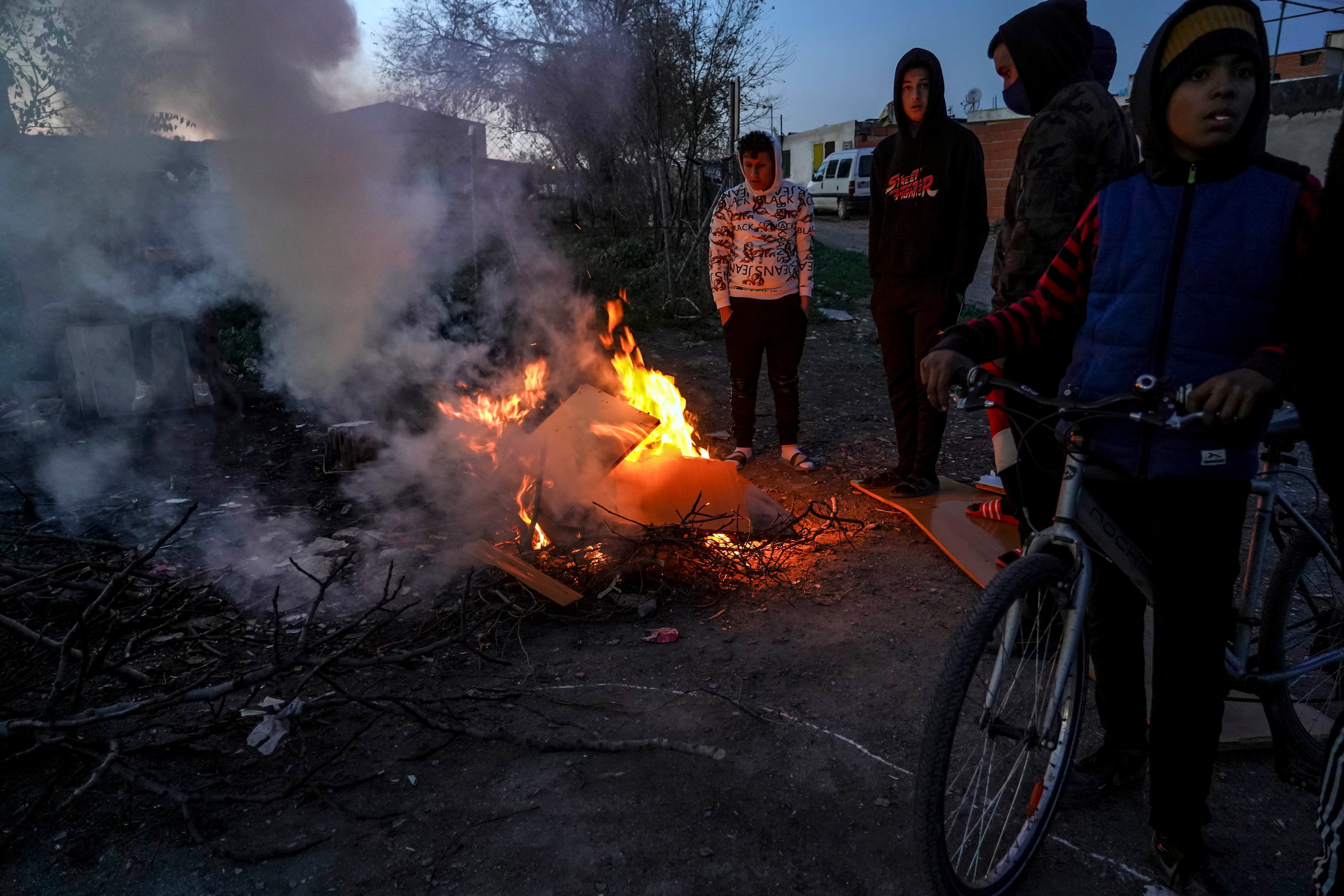 Un grupo de jóvenes alrededor de una fogata al caer la tarde en el sector seis de la Cañada