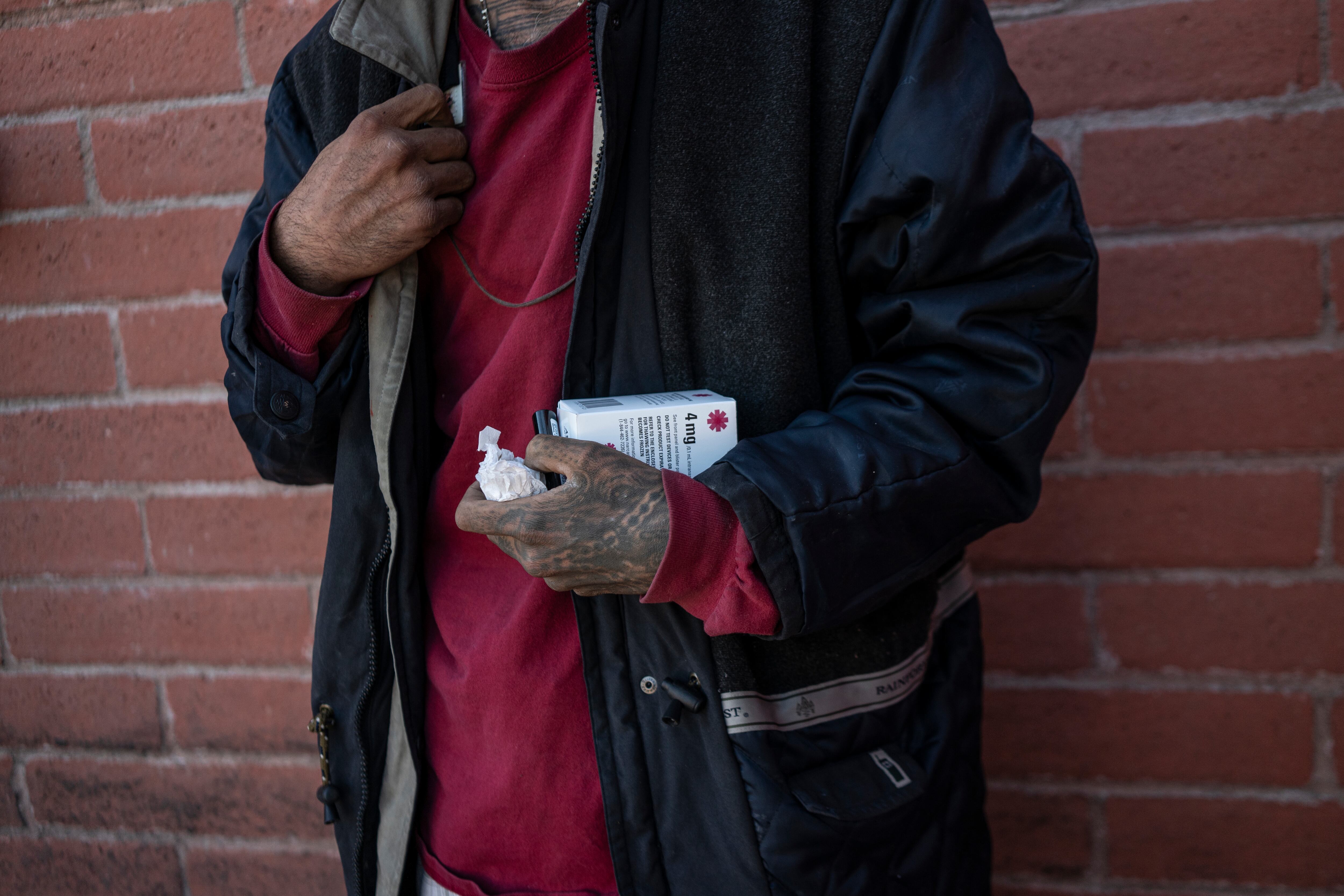 'Ricky' un hombre sin hogar y adicto a las drogas, sostiene una caja de Naloxona, medicamento que revierte las sobredosis de fentanilo, en Nogales, Arizona (EE UU), en diciembre de 2023.