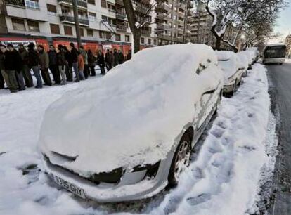 Turismos cubiertos por la nieve en una céntrica calle de Vitoria.