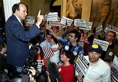 El senador Stan Rosenberg informa del resultado de la votación subido en una mesa, ante partidarios y detractores de las bodas entre <i>gays</i>.