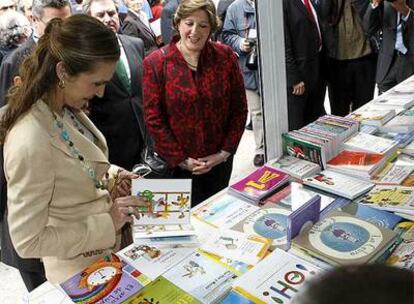 La Infanta Elena hojea un libro en uno de los <i>stands</i>.