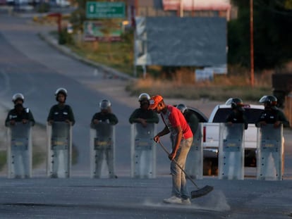 Un hombre barre la calle a lo largo de la frontera entre Venezuela y Brasil en Pacaraima.