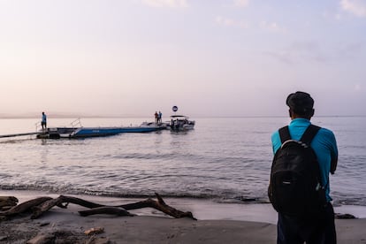 Un migrante venezolano observa la partida de una embarcación con destino a la selva del Darién, en Necoclí (Colombia), en marzo de 2024.