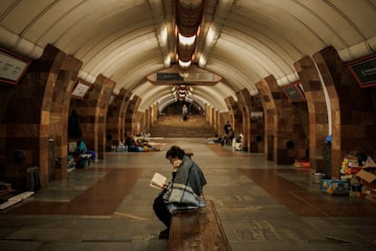 Una mujer lee un libro este lunes en una estación de metro en Járkov, en el noreste de Ucrania, mientras se refugia de un bombardeo ruso.