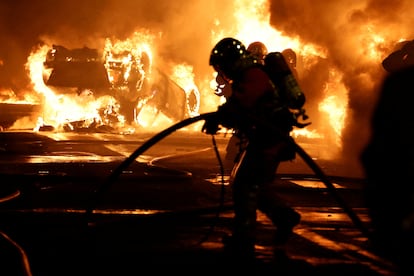 Firefighters extinguish burning vehicles during clashes between protesters and police, after the death of Nahel, a 17-year-old teenager killed by a French police officer during a traffic stop, in Nanterre, Paris suburb, France, June 28, 2023.