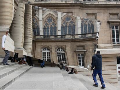 Dos trabajadores transportan un espejo en el que se refleja la Santa Capilla de París el pasado 5 de mayo.