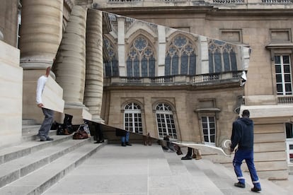 Dos trabajadores transportan un espejo en el que se refleja la Santa Capilla de París el pasado 5 de mayo.