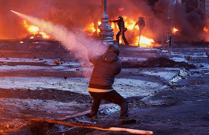 Los manifestantes ucranianos disparan cohetes y queman neum&aacute;ticos de autom&oacute;viles durante los enfrentamientos en al calle Grushevsky de Kiev.