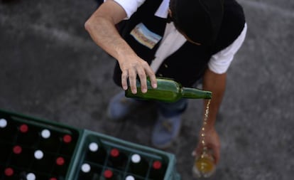 Un hombre escancia sidra en una feria en Gijn.