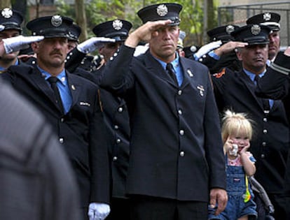 Un grupo de bomberos de Nueva York, ayer, saluda a su paso a la familia de Peter Bielfeld, un compañero fallecido el 11-S, durante su funeral. PLANO MEDIO - ESCENA