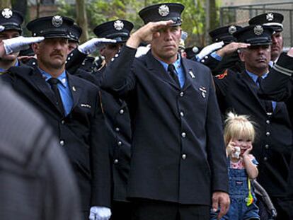 Un grupo de bomberos de Nueva York, ayer, saluda a su paso a la familia de Peter Bielfeld, un compañero fallecido el 11-S, durante su funeral. PLANO MEDIO - ESCENA