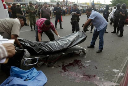 Los forenses levantan los cadáveres de dos policías muertos a tiros en la ciudad de Culiacan, en el estado de Sinaloa