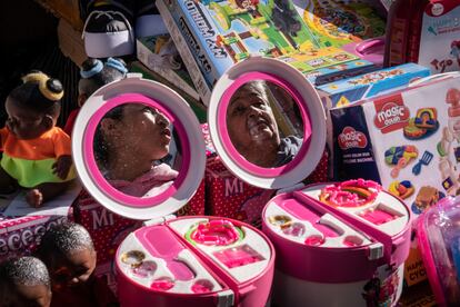 Reflejo de una niña y una mujer en un espejo de los miles de accesorios a la venta en la jornada conocida como "el madrugón".