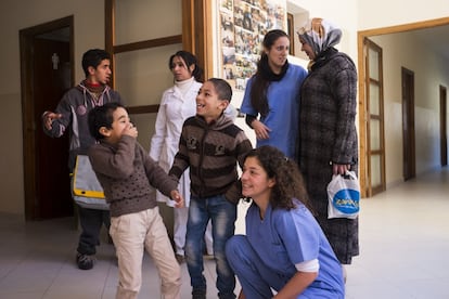 Eva Montero, fisioterapeuta, y Cristina Morgades, terapeuta ocupacional, despiden a una familia cuyos niños acaban de recibir una sesión de terapia.