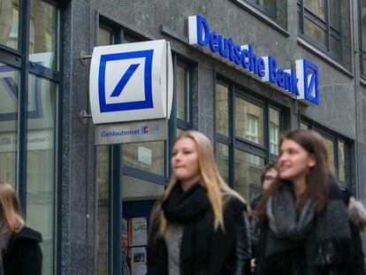 Un grupo de j&oacute;venes pasea frente a una sucursal de Deutsche Bank en Hamburgo (Alemania).