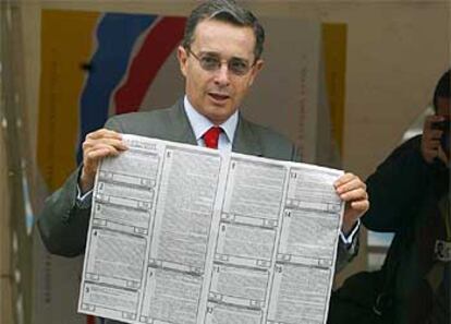 El presidente de Colombia, Álvaro Uribe, muestra su impreso de voto antes de depositarlo.