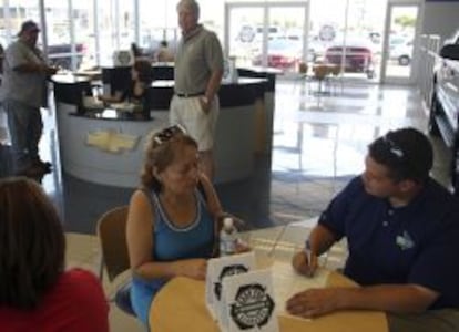 Una cliente formalizando una compra en un concesionario de Chevrolet.